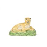 A STAFFORDSHIRE FIGURE OF A LEOPARD EARLY 19TH CENTURY modelled recumbent, facing right, in