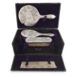 A matched cased four-piece Chinese export silver dressing table set,