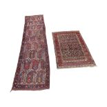 A small Persian wool rug with muti-floral panel within running borders, and a further Eastern runner