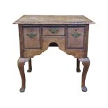 A Georgian oak lowboy fitted with an arrangement of three frieze drawers with crossbanded detail
