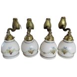 A set of four brass wall lights with transfer printed moulded glass shades
