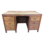 A mouseman kneehole desk in oak with adze and chamfered detail within a panelled frame, fitted