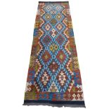 A Chobi kilim runner with bright geometric details. 247cm x 85cm.