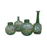 A hand blown green tinted glass long necked bottle shape vase 54cm high together with three