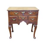 A George III period country made walnut lowboy with four drawers, herringbone inlaid detail and a