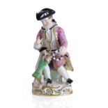 A Continental group as a seated gentleman and his performing dog, late 19th century,