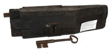 A 17th Century Oak-Cased Lock, with original key, the case crudely hewn and adzed 67cm by 18cm