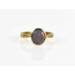 An 18ct gold and opal ring, the circular black opal in enclosed setting, size K/L, 3.6g.