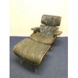 Charles and Ray Eames chair and a footstool upholstered in black leather.