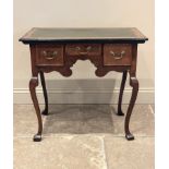 A George III oak lowboy, the rectangular top inset with green leather skiver above an arrangement of