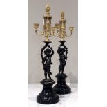 A pair of ormolu mounted patinated bronze figural candelabra, 19th century, each modelled as a putto