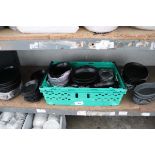+VAT Shelf of black crockery, mostly oval dishes, serving platters and tapas bowls