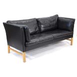 A 1970's Danish three-seater sofa upholstered in black leather, on beech legs, w. 184 cm *Sold