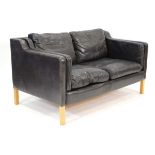 In the manner of Borge Mogensen (Danish, 1914-1972), a two-seater sofa upholstered in black leather,