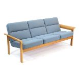 A 1970's Danish three-seater sofa by Magnus Olesen, the oak framed supporting pale blue seats, w.