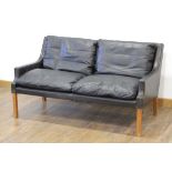 A 1960's Danish two-seater sofa upholstered in black leather on square legs, w. 131 cm *Sold subject