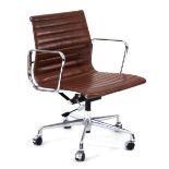 A desk chair in the style of Charles & Ray Eames, with a brown seat, chromed arms and five-star