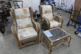 Pair of cane conservatory armchairs with matching glass top coffee table