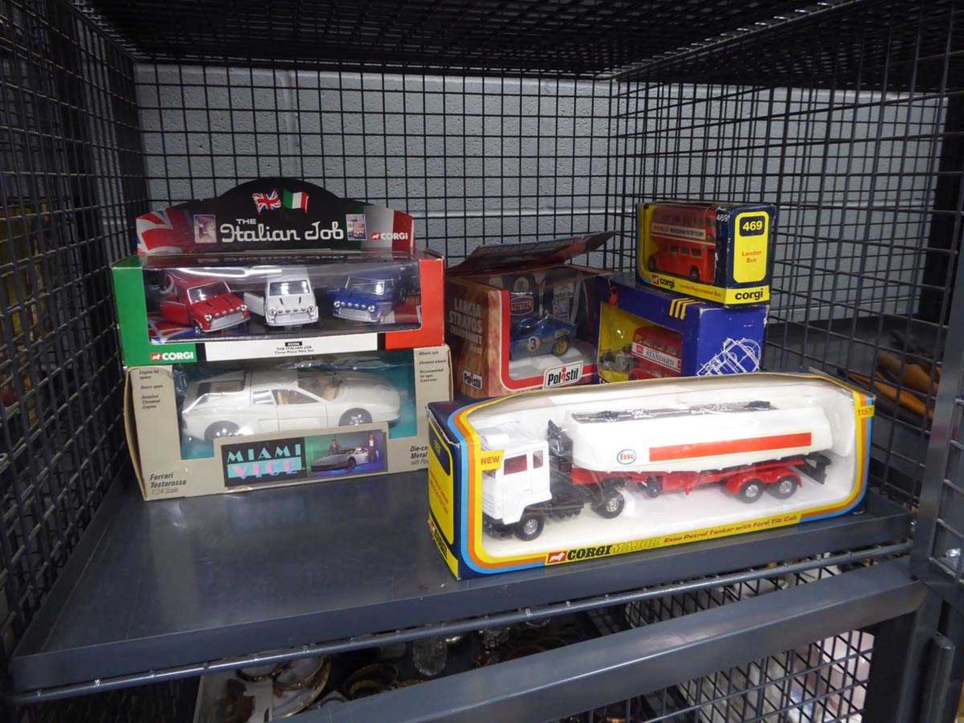 Cage containing Corgi and other boxed diecast vehicles