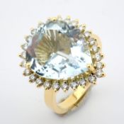An 18k yellow gold cluster ring detailed with 6.57 ct aquamarine and brilliant