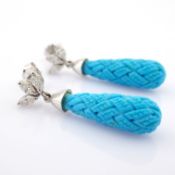 An exquisite earrings detailed with carved turquoise, brilliant diamonds and