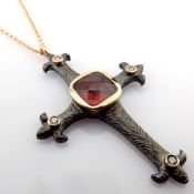 An exquisite cross necklace detailed with red garnet, brilliant diamonds and gold on