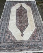 A Bokhara carpet. Beige grounds with a geometric border and central shield (300cm x 200cm)