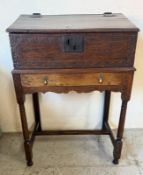 An oak bible box with a hinged sloping front opening to two pigeon holes, original mounts and on a