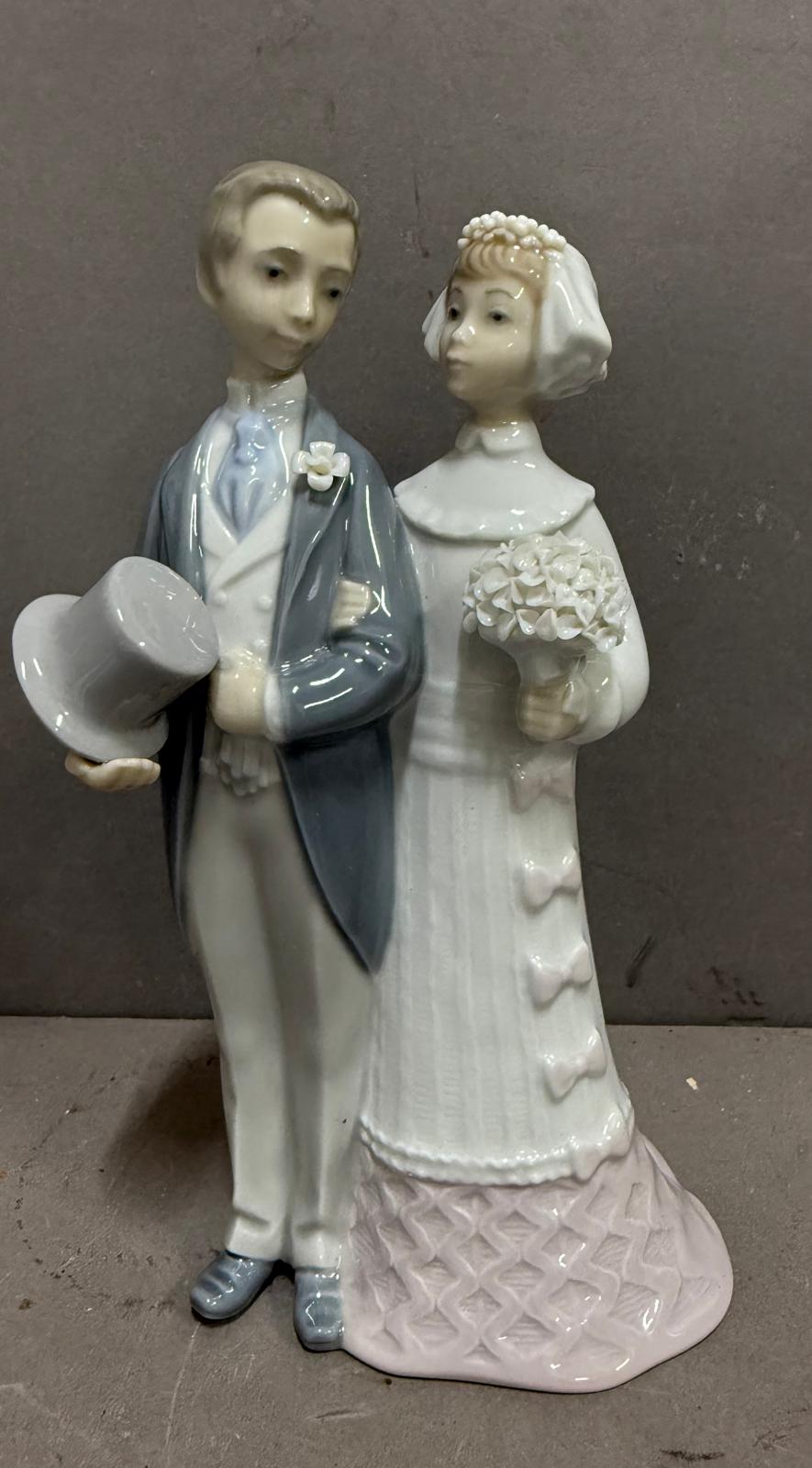 A Lladro figure of a bride and groom on their wedding day.