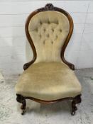 A Victorian walnut spoon back nursing chair upholstered in pale green