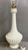 A white ceramic ribbed table lamp