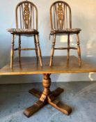 Oak dining table by Littmoron and Goodwin along with two wheel back chairs (H76cm W120cm D90cm)