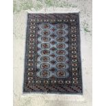 A wool prayer mat. Blue grounds with geometric border. 125x78cm
