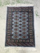 A wool prayer mat. Blue grounds with geometric border. 125x78cm