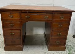 A mahogany kneehole desk comprising of one long drawer flanked by eight short. The writing surface