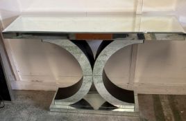 A Venetian mirrored console table with a central out scrolling support column on a rectangular base.