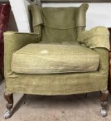 1960's green upholstered armchair on cabriole legs and castors