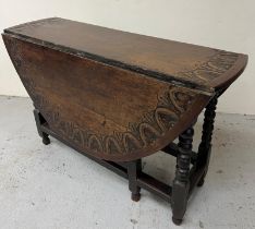An oak gate leg dining table with drawer to one end, carved boarder to edge of table. H 76cm x 132cm