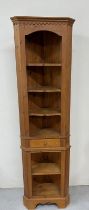 A pine corner cabinet with six shelves and a central drawer. H 206cm x W 53cm x 31cm