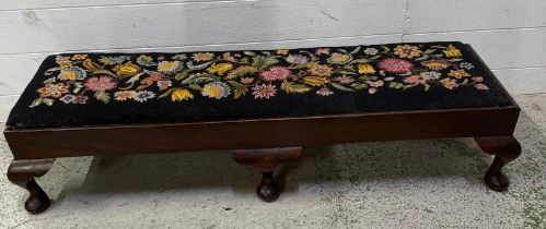 A mahogany long foot stool on cabriole legs, upholstered in a black floral fabric