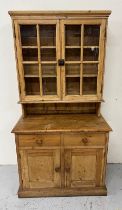 A pine dresser with glazed double door cabinet set over two drawers and double doored storage. H