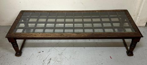 A oak glass topped coffee table on turned supports (H32cm x 130cm x 52cm) Condition Report Some