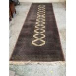 A Bukhara runner rug with ivory coloured central pattern and dark contrasting border 310cm x 100cm